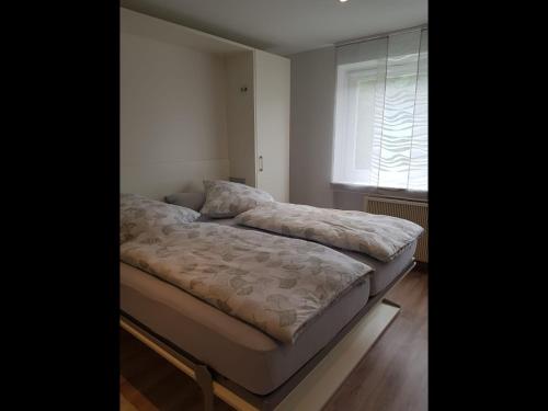 uma cama num pequeno quarto com uma janela em NEU! Ferienwohnung Mien lütte Boe SPO em Sankt Peter-Ording