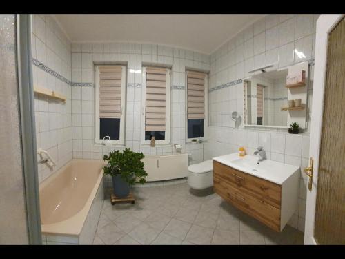 y baño con bañera, lavamanos y bañera. en NEU! Ferienwohnung Unger, en Schwarzenberg