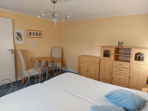 een slaapkamer met een bed en een tafel en stoelen bij NEU! Morderne Ferienwohnung Hohenzieritz in Hohenzieritz