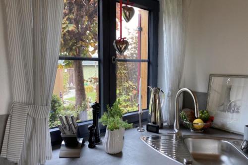 a kitchen counter with a window and a sink at Die Schorenmoos-Lodge in Dietmannsried