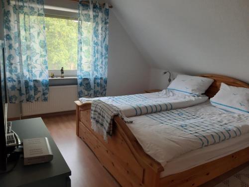 a bedroom with a wooden bed with a window at NEU! Fewo Merle mit Balkon in Carolinensiel