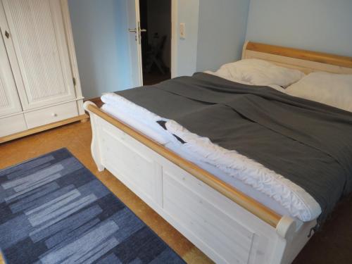 Ce lit se trouve dans une chambre dotée d'un cadre de lit blanc. dans l'établissement FeWo Schwalbennest Dornumersiel, à Dornumersiel