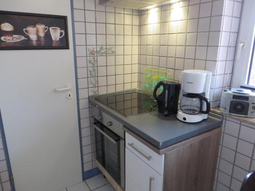 a kitchen with a counter with a coffee maker on it at Ferienwohnung Hafenkoje in Dornum