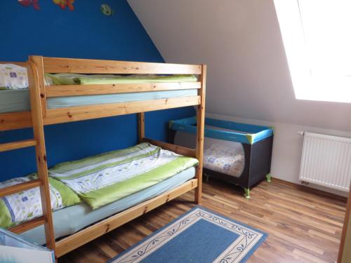 two bunk beds in a room with a blue wall at NEU Nordseeferienhaus An der Mühle in Westerholt