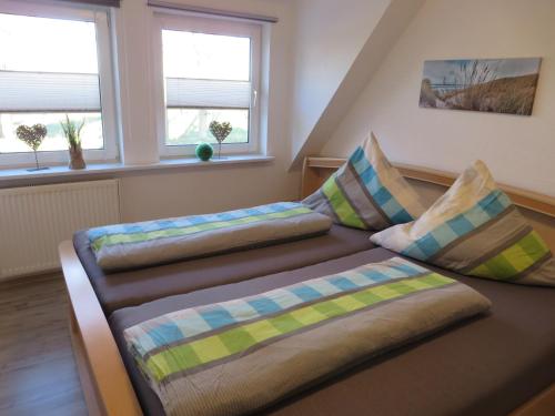 two beds in a room with two windows at NEU! Ferienwohnung Nordlicht in Großheide