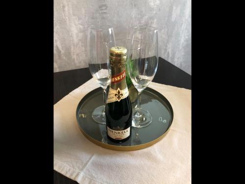 eine Flasche Champagner und zwei Weingläser auf dem Tisch in der Unterkunft NEU! Ferienhaus Schliephake in Schöningen