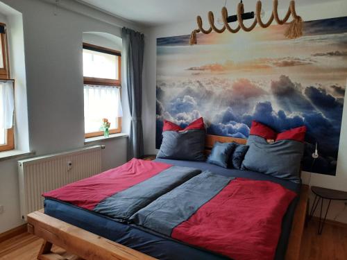 a bedroom with a bed with a painting on the wall at NEU! Geschmackvolle FeWo Lengenfeld in Lengenfeld