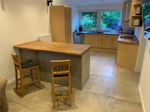 a kitchen with a wooden counter and two chairs at NEU! Ferienwohnung MOIN in Langwedel