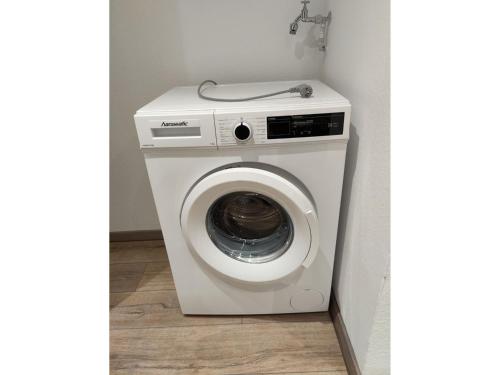 a white washing machine in a corner of a room at NEU Ferienwohnung Wildgans Dollart Ostfriesland in Bunde