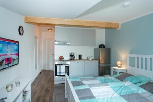 a small bedroom with a bed and a kitchen at NEU! Appartement Zur Heidschnucke in Toppenstedt