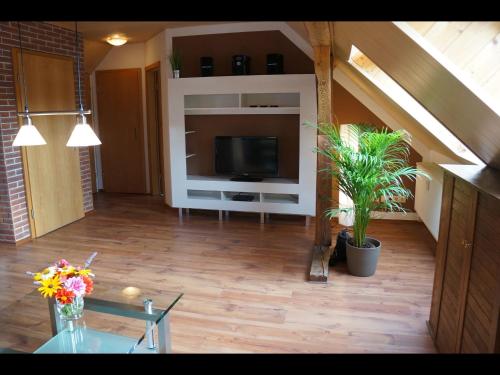 a living room with a flat screen tv and a table at NEU! Schorfheider FeWo Eberswalde in Eberswalde