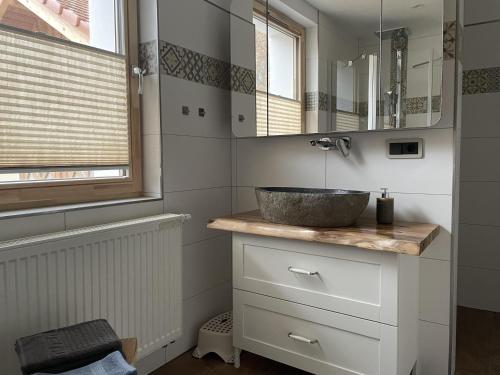 ein Bad mit einem Waschbecken und einem Spiegel in der Unterkunft NEU! Haus am Heldrastein in Treffurt