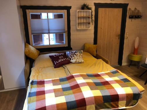 a bedroom with a bed with a colorful blanket at NEU! Ferienhütte Tiny House in Schöningen