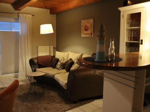 ein Wohnzimmer mit einem Sofa und einem Tisch in der Unterkunft NEU! Schicke Ferienwohnung Niebüll in Niebüll