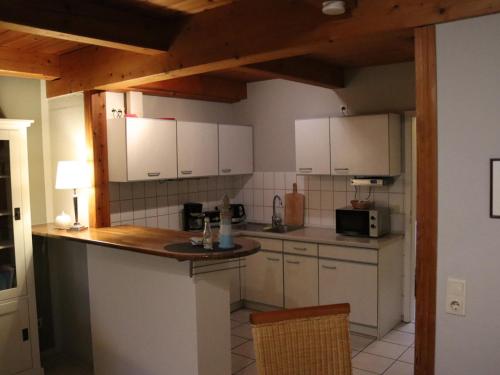a kitchen with white cabinets and a counter top at NEU! Schicke Ferienwohnung Niebüll in Niebüll