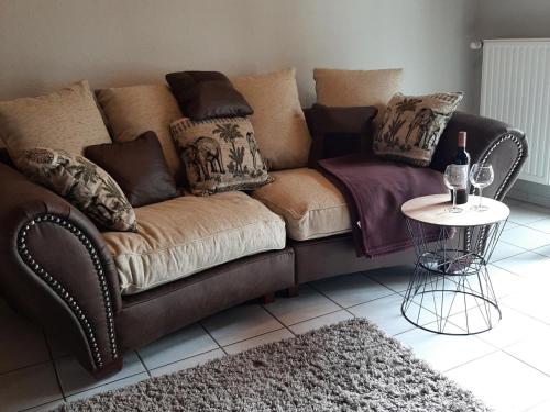 a living room with a brown couch and a table at NEU! Schicke Ferienwohnung Niebüll in Niebüll