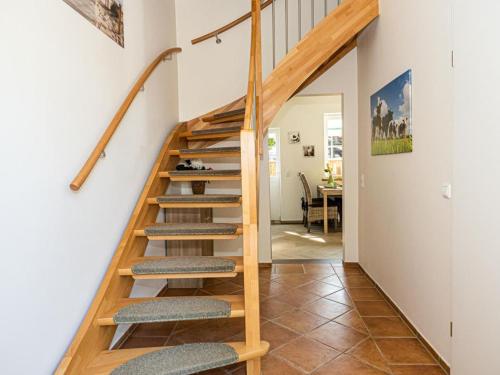 a wooden staircase in a home with a living room at Ferienwohnung Meer und Muh in Strenglin