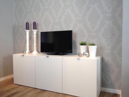 a white cabinet with a tv on top of it at NEU! Modernes Ferienhaus Strandgut in Garrel