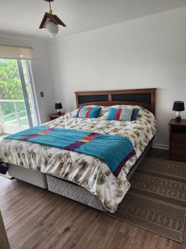 a bedroom with a large bed with a wooden headboard at Quebrada de la Candelaria II in Algarrobo