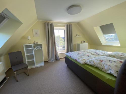 una camera da letto con un letto, una sedia e una finestra di NEU Ferienhaus Dat Wildberghus a Wildberg