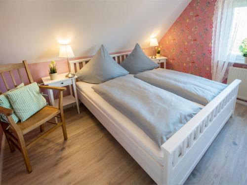 1 cama blanca grande en una habitación con silla en !NEU! Komfort Ferienhaus Polly, en Dornum