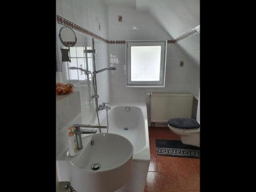 a bathroom with a tub and a toilet and a sink at NEU Elizahaus-Ringbergblick Suhl in Suhl