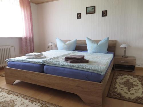 Schlafzimmer mit einem Bett mit blauer Bettwäsche und blauen Kissen in der Unterkunft NEU! Schöne Nordsee-FeWo Kölker in Nenndorf