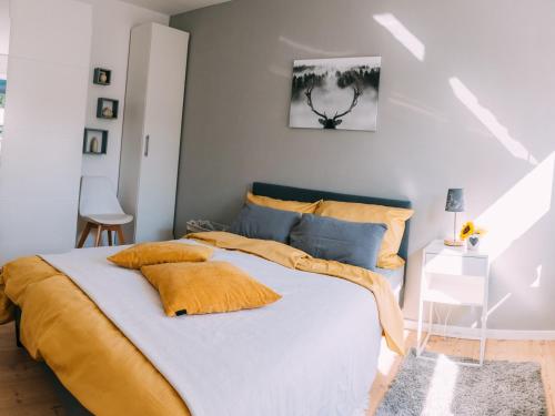 ein Schlafzimmer mit einem großen Bett mit gelben und blauen Kissen in der Unterkunft NEU! Ferienhaus Handeloh in Handeloh