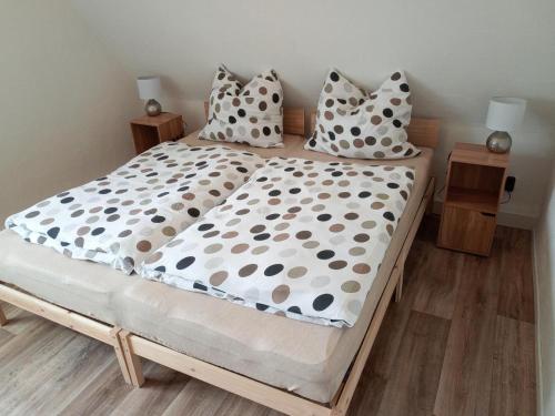 Cama con almohadas y sábanas de lunares en Ferienwohnung am Hambach, 