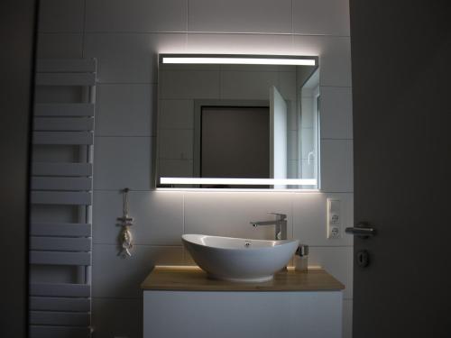 een badkamer met een wastafel en een spiegel bij NEU! Ferienhaus Nordeck in Berumbur