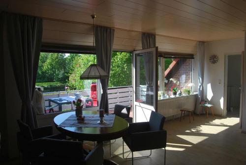 a living room with a table and chairs and a patio at NEU! Schönes Urlaubsdomizil an der Nordsee in Stedesdorf