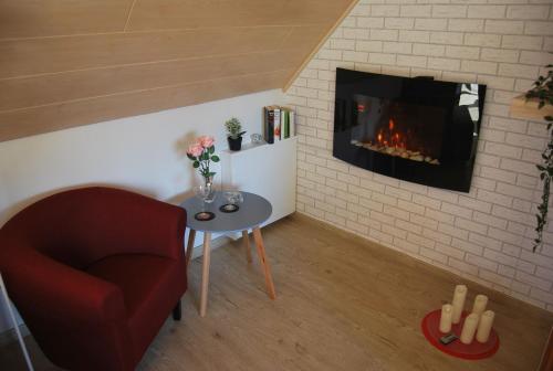 a living room with a fireplace and a chair and a table at NEU! Schönes Urlaubsdomizil an der Nordsee in Stedesdorf