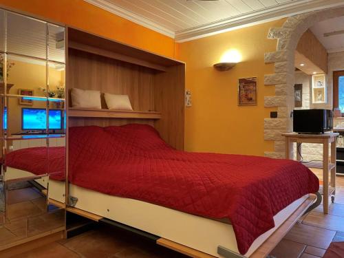 a bedroom with a bed with a red comforter at Ferienwohnung Le Paradis in Bad Ems