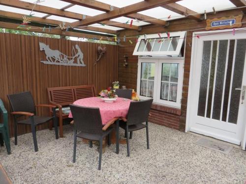 a patio with a table and chairs and a door at !!!NEU!!! Nordsee-Ferienwohnung Ahrendt in Westerbur