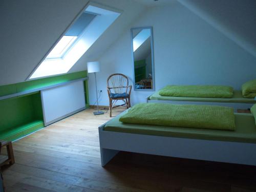 a attic bedroom with two beds and a chair at NEU! Komfort Ferienwohnung Friesenwind in Utarp