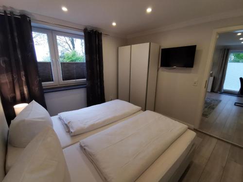 two beds in a room with a tv and a room at NEU Ferienhaus Musenburg Apartment W2 in Stedesand