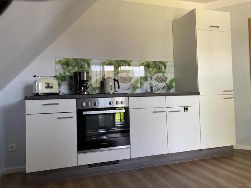 胡蘇姆的住宿－NEU Ferienwohnung Hofmann，厨房配有白色橱柜和烤箱。