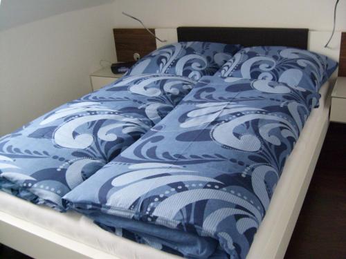 a bed with a blue and white comforter on it at !!!NEU!!! Ferienwohnung am Deich in Dornumersiel