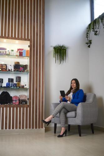 a woman sitting on a chair with a laptop at Hotel Montecarlo in Ibarra