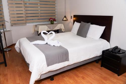 a bedroom with a bed with two swans on it at Hotel Montecarlo in Ibarra