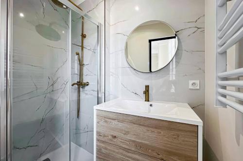 ein Bad mit einem Waschbecken und einem Spiegel in der Unterkunft LE PANORAMIQUE in Nizza