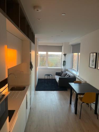 a living room with a couch and a table at AEROPARTMENT & AEROTEL, London Heathrow Airport, Terminal 4, EV Stations & Cheap Parking on site! in West Bedfont