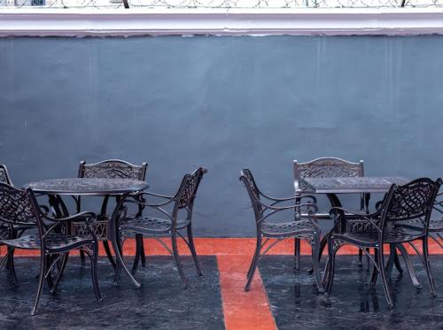 a group of tables and chairs in front of a wall at Triple Tee Hotel & Service Apartments in Ikeja
