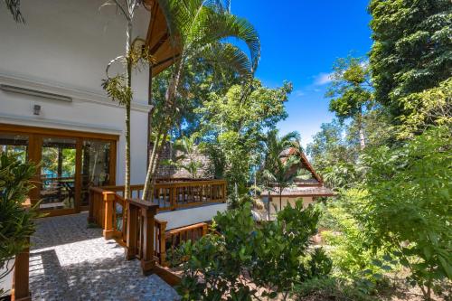 a porch of a house with a swing at 悬崖别墅 无边海景 直达海滩 五卧泰式独栋私人泳池别墅 超漂亮日出 in Phuket Town