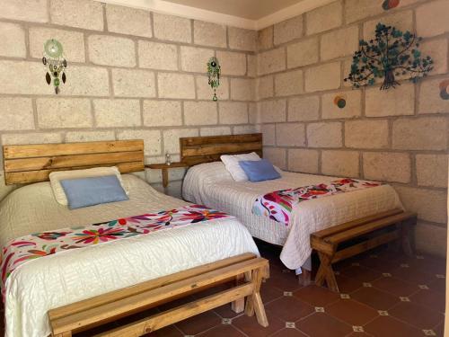 a room with two beds and benches in it at Boutique la Posada de Don Luis in Bernal