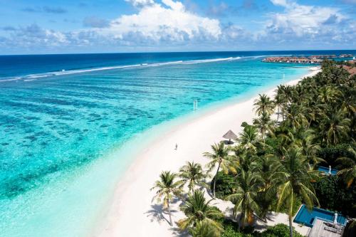 an aerial view of a beach with palm trees and the ocean at Radisson Blu Resort Maldives in Fenfushi