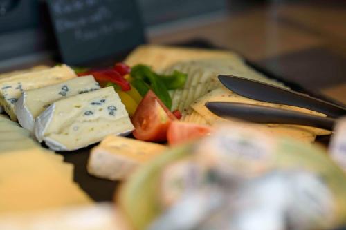 a plate of food with cheese and fruit on a table at Campanile Berlin Brandenburg Airport in Schönefeld