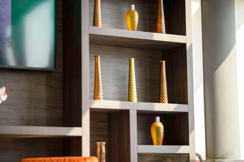 a shelving unit with vases and cornucopia at Campanile Berlin Brandenburg Airport in Schönefeld