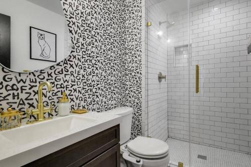 a black and white bathroom with a toilet and a sink at Carrollton Beautiful House with Pool in Carrollton