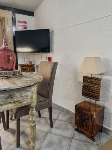 a room with a table and a chair and a lamp at Estúdio em Alte - KARMEA HOUSES in Alte